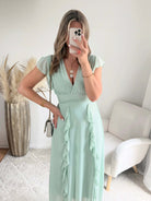 Robe Madison longue fluide à volants avec décolleté cache-cœur et manches volantées, disponible en vert d’eau, rose poudré et fuchsia, taille unique du 36 au 42.