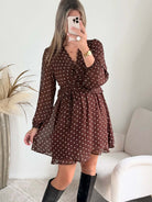Femme portant une robe courte à pois marron 