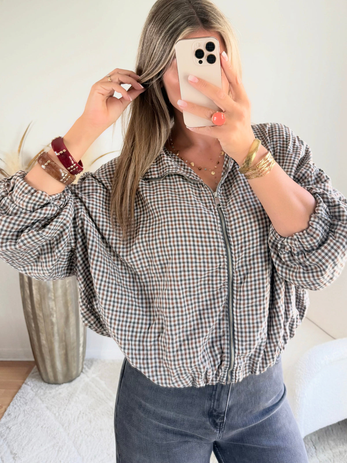 Femme portant le blouson court Tao à petits carreaux gris, marron et écru.