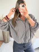 Femme portant le blouson court Tao à petits carreaux gris, marron et écru.