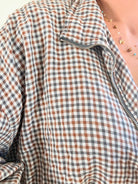 Femme portant le blouson court Tao à petits carreaux gris, marron et écru.