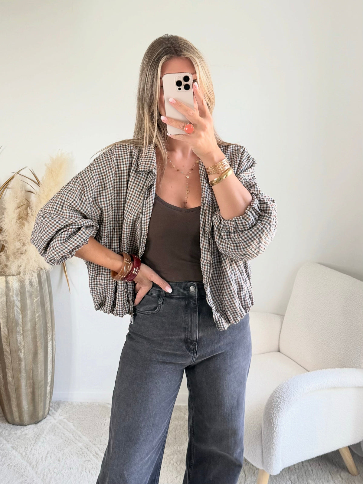 Femme portant le blouson court Tao à petits carreaux gris, marron et écru.