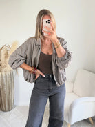 Femme portant le blouson court Tao à petits carreaux gris, marron et écru.