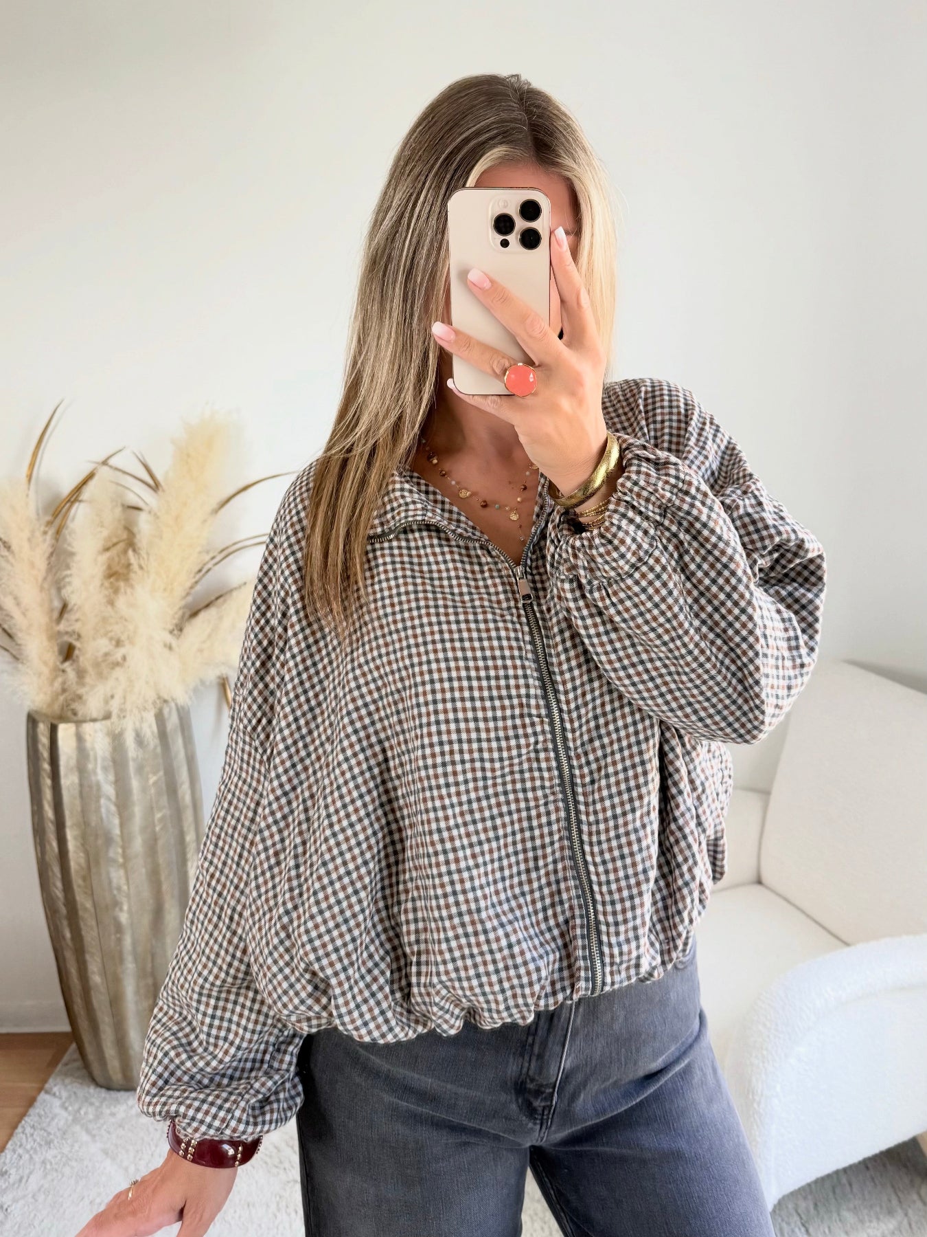 Femme portant le blouson court Tao à petits carreaux gris, marron et écru.