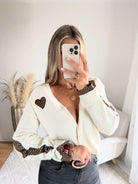Cardigan écru aussi doux qu’original. Avec des empiècements marrons à petits pois.