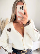 Cardigan écru aussi doux qu’original. Avec des empiècements marrons à petits pois.