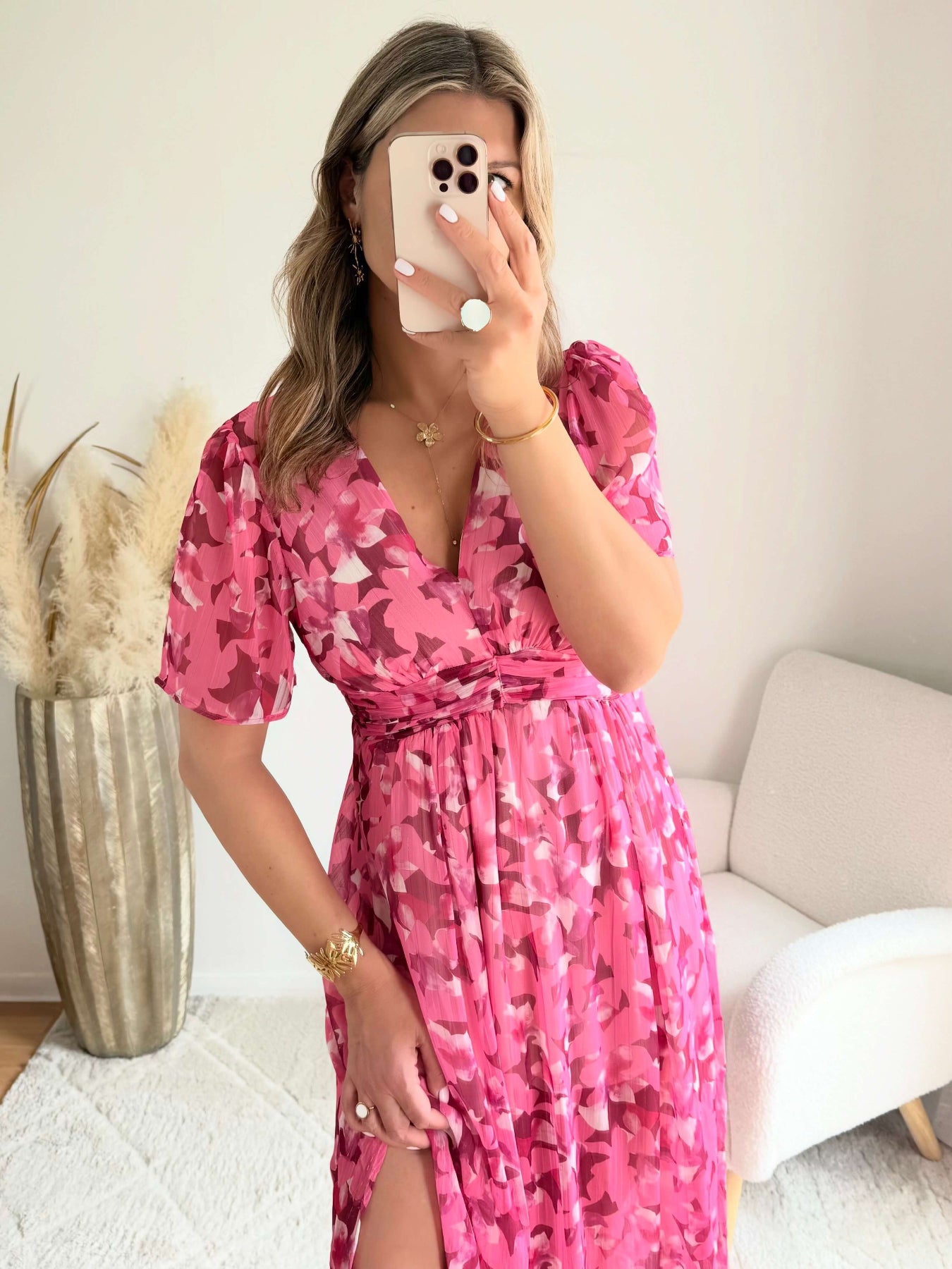Robe longue plissée rose à imprimé floral avec manches fluides et décolleté croisé.